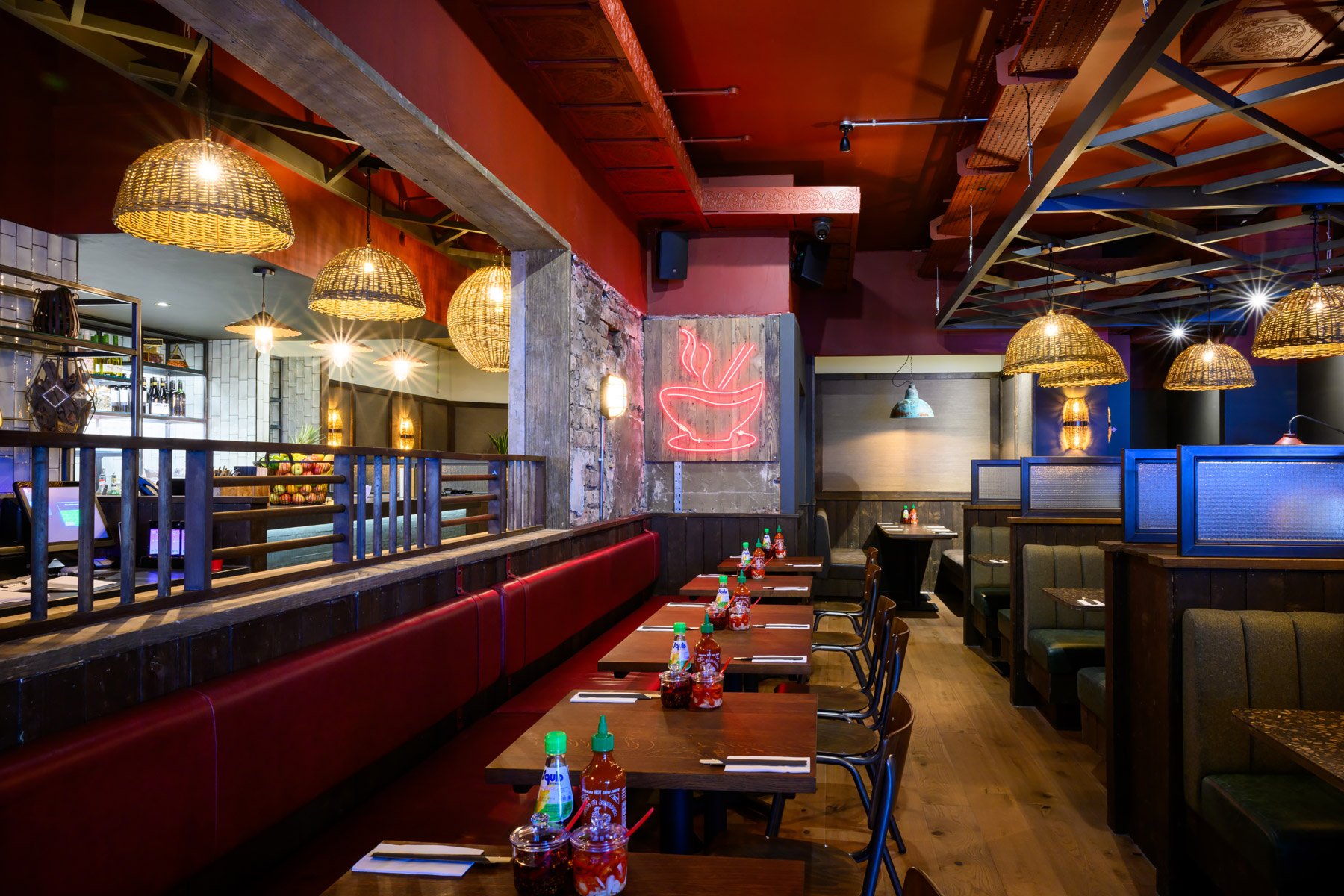 Wide-angle interior shot of a cozy restaurant dining room with warm ambient lighting.
