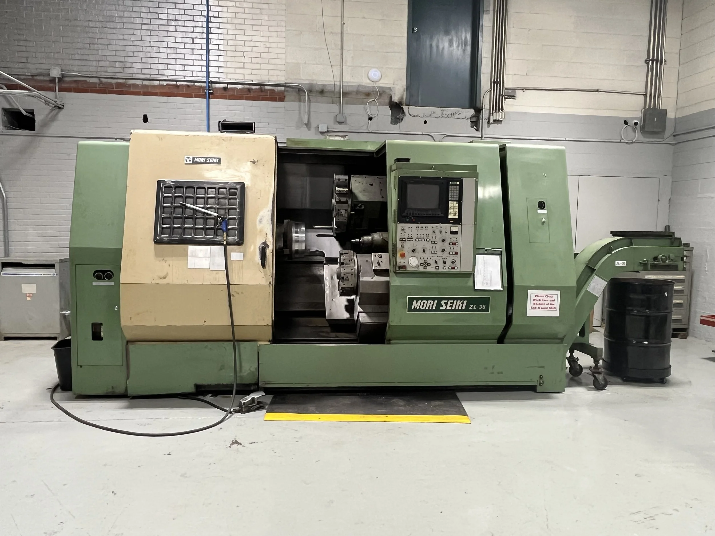 A large green and beige Mori Seiki ZL-35 CNC lathe machine in a workshop.