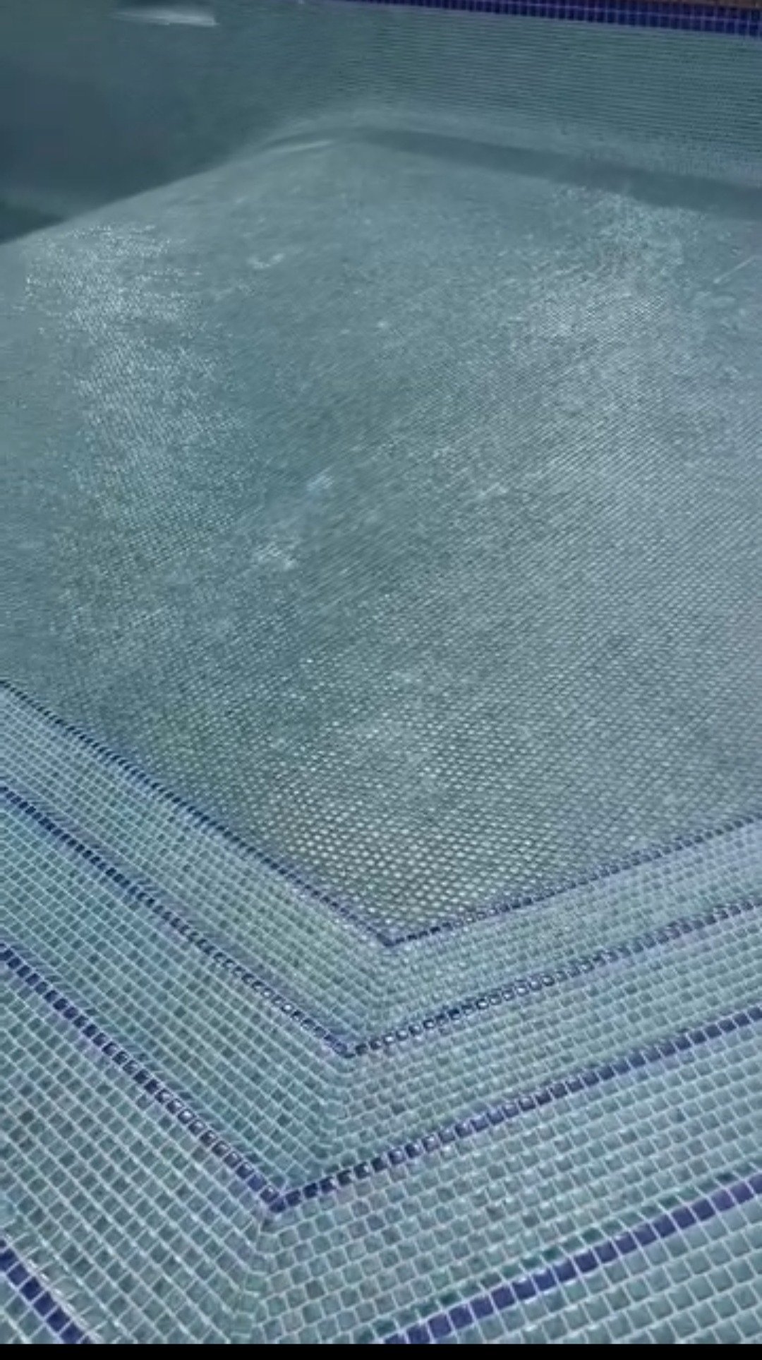 Close-up of a glass or acrylic surface with a textured pattern, likely a window or protective screen.