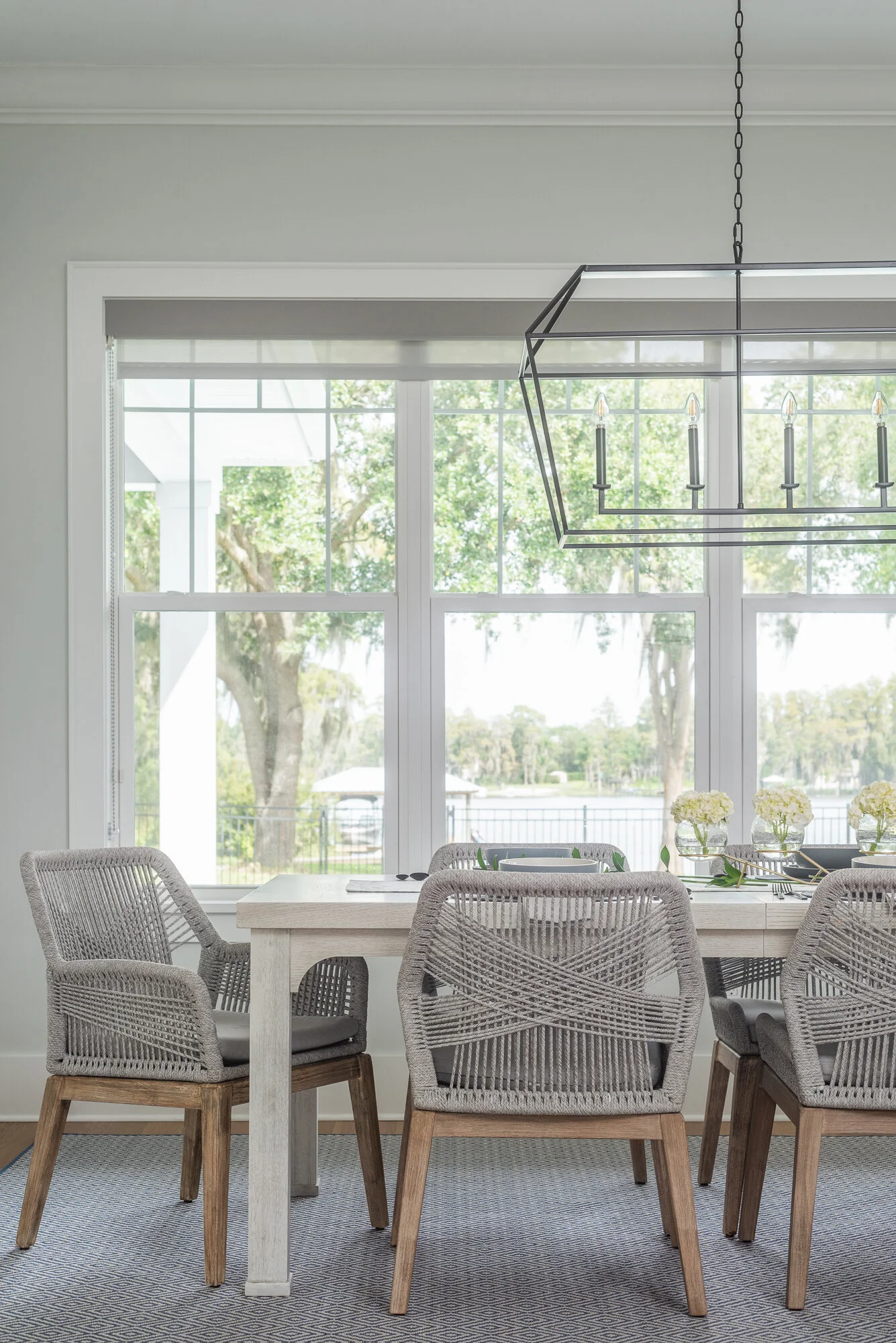 Light brown woven chairs for dining room with black metal chandelier