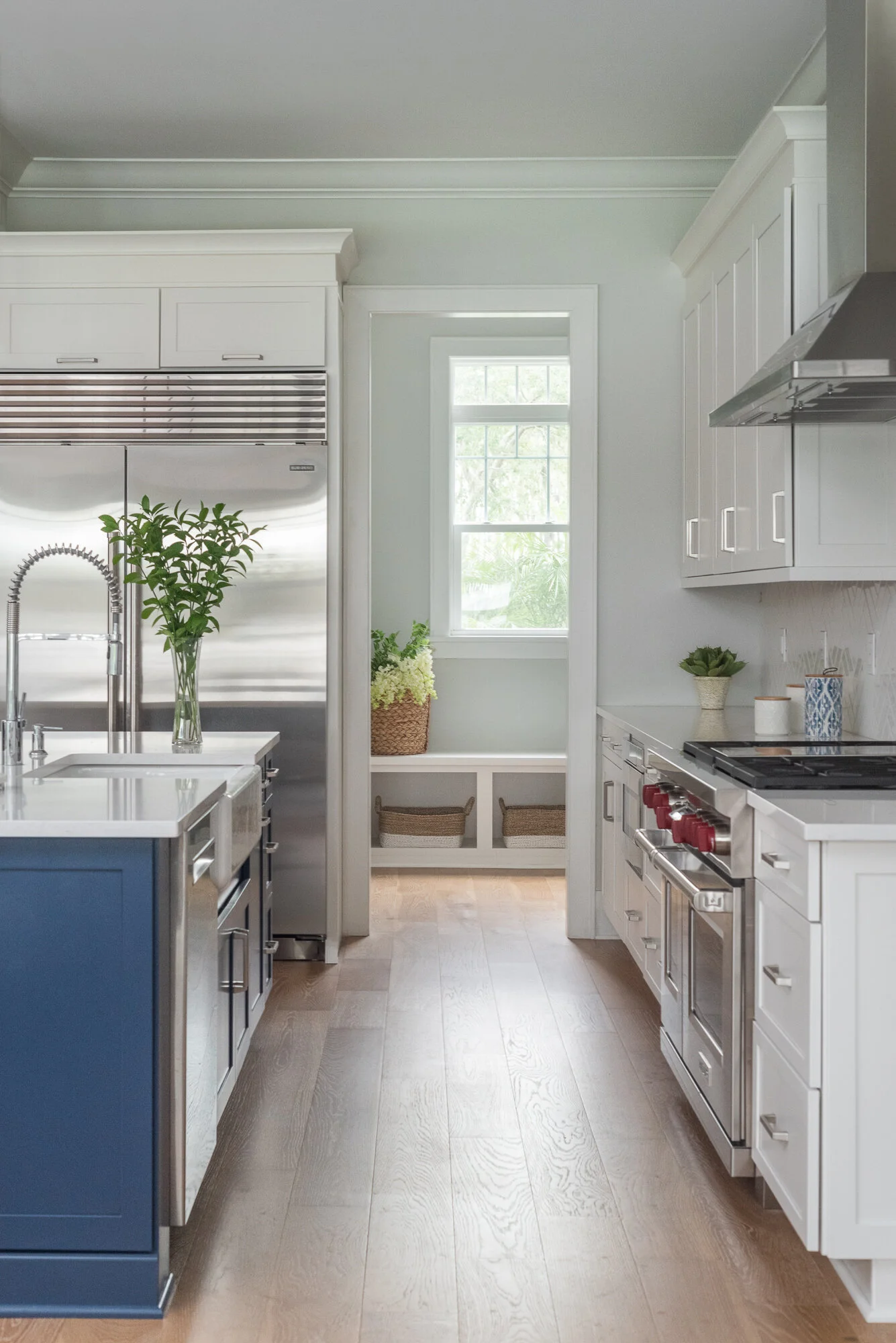 white and grey kitchen with woven bar stools and dark blue island