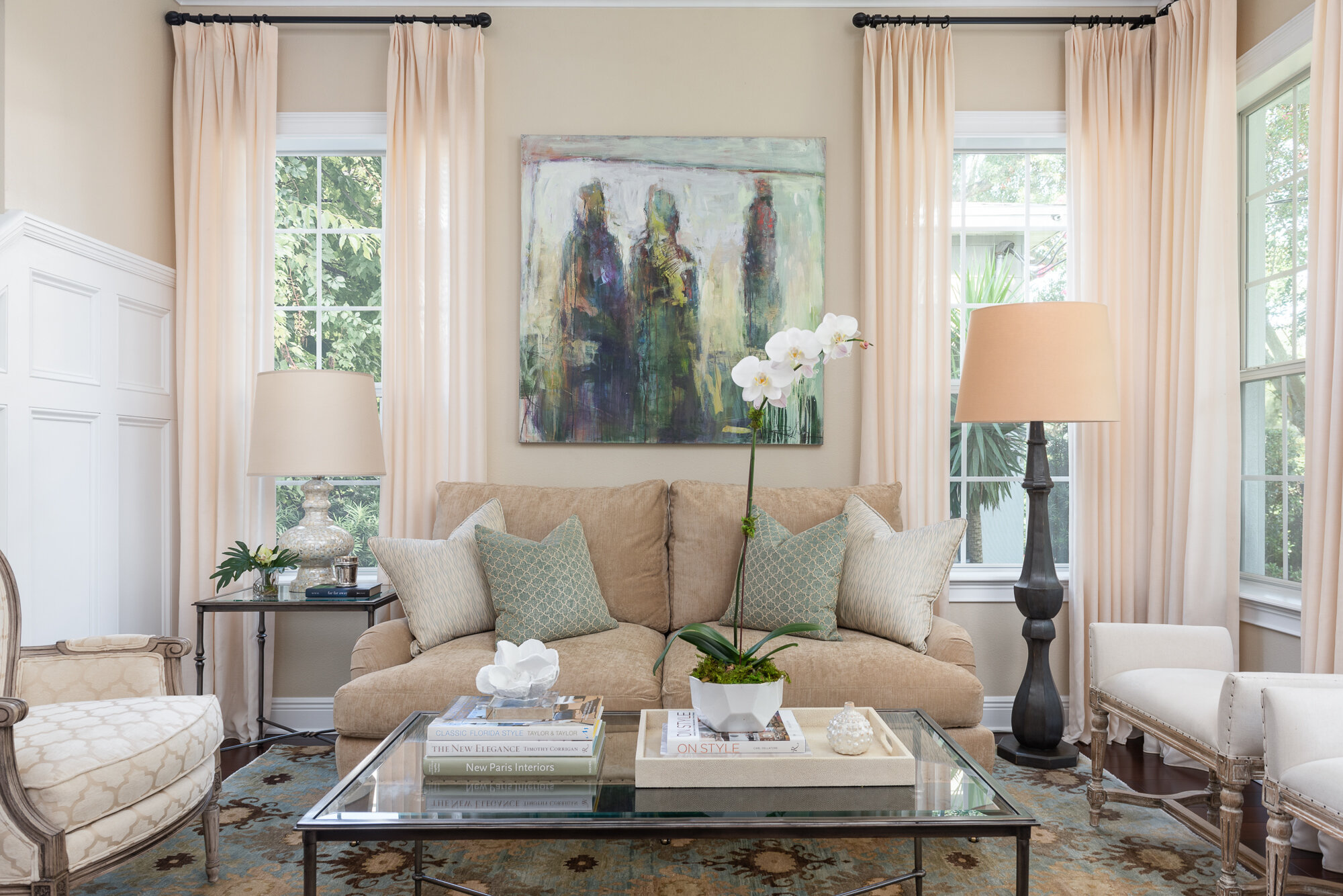 Traditional warm living room with couch, chandelier, coffee table, window treatment
