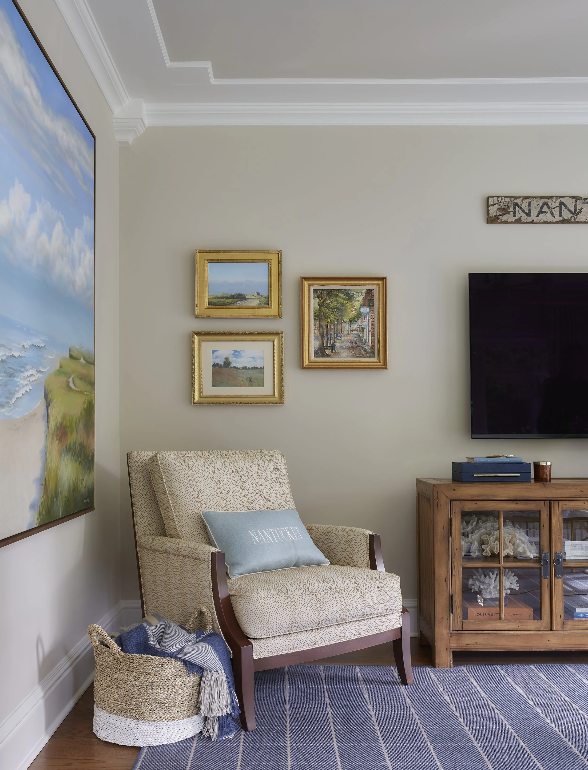  Beige upholstered chair in front of a curated gallery wall 
