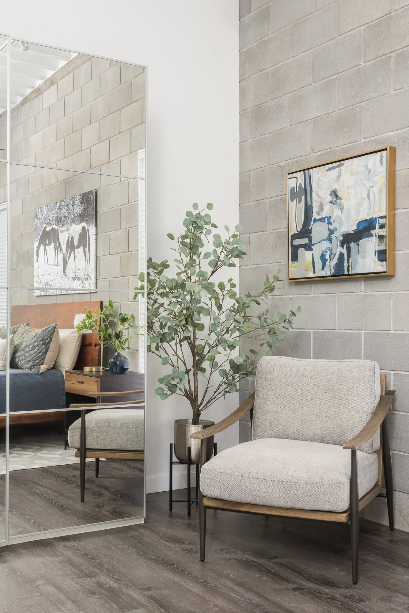  Neutral wood-frame chair beside a full-length mirror 