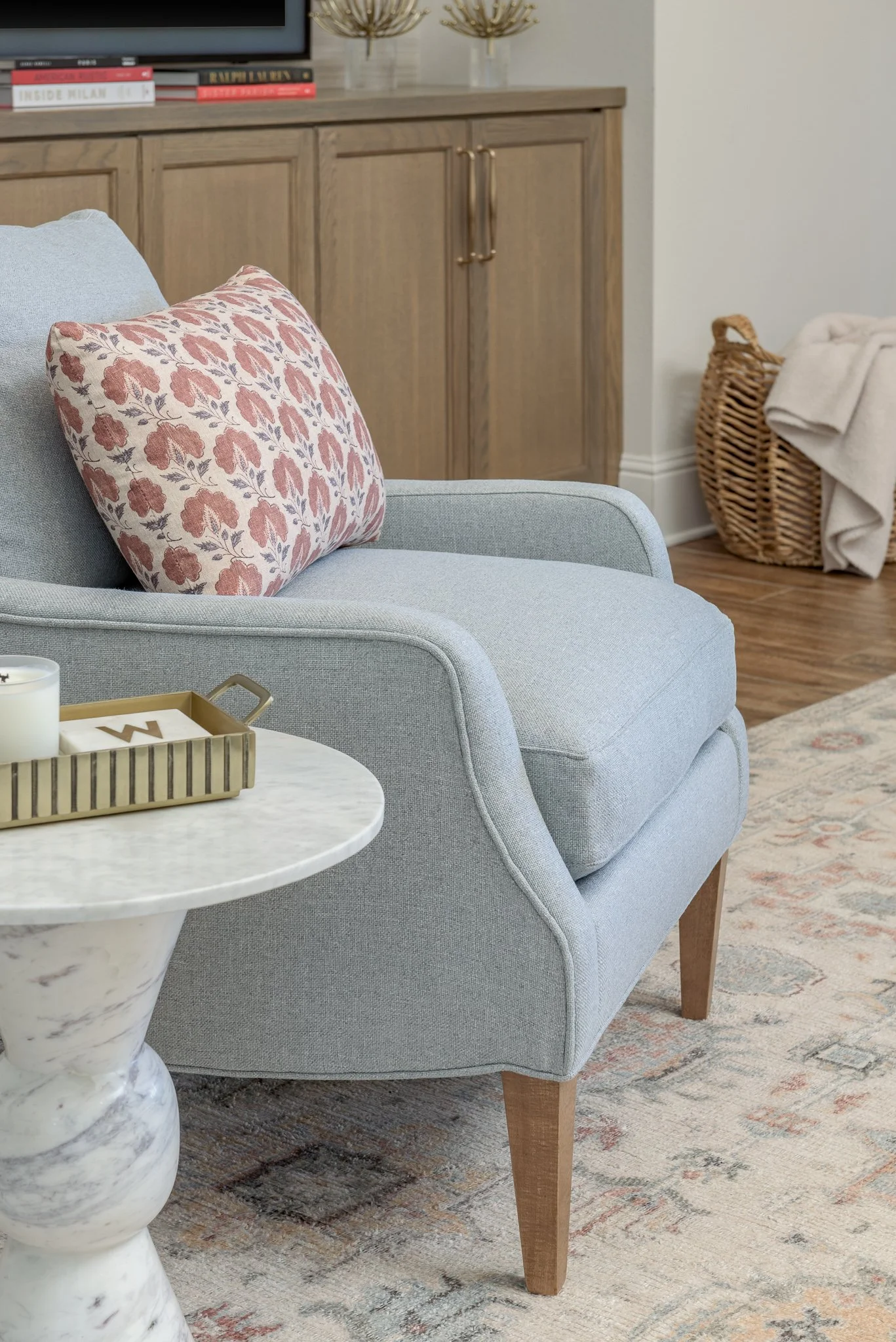  Light blue tailored armchair with a floral pillow 