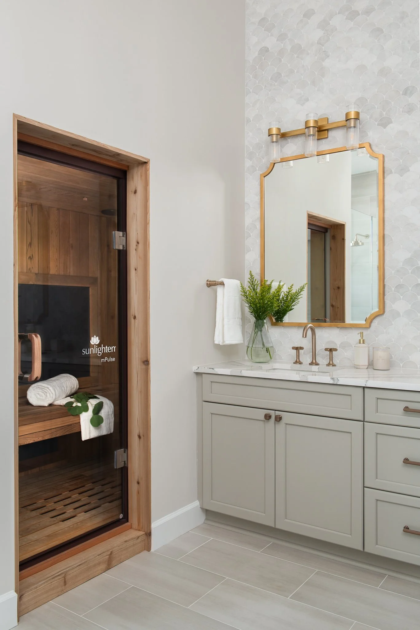 Modern bathroom with a sauna on the left and a vanity with a mirror and plant on the right.