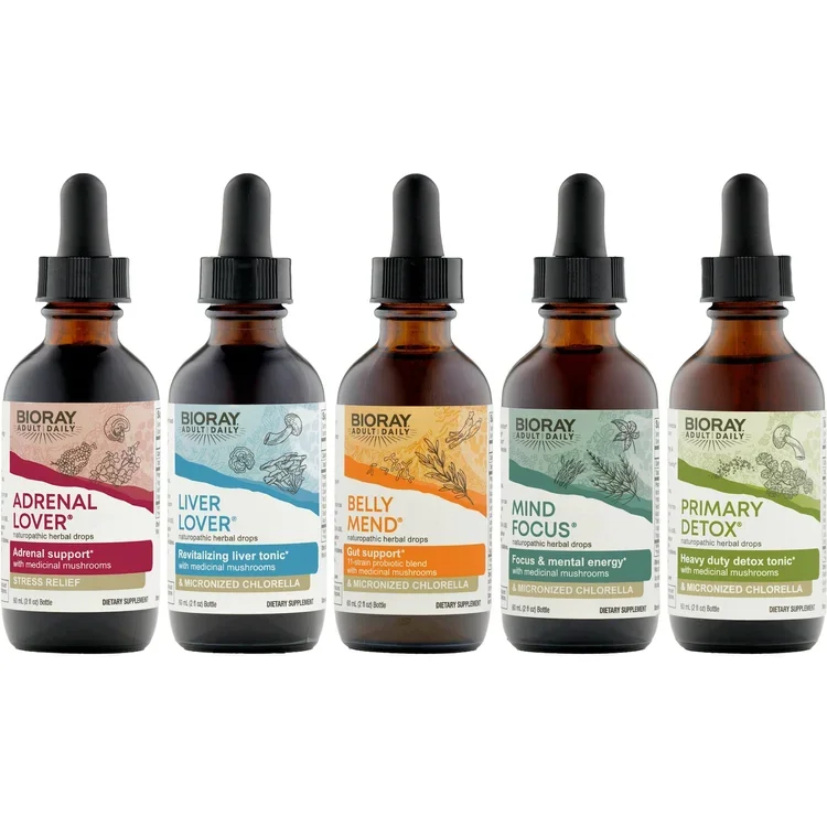 Five brown glass bottles of herbal drops labeled Adrenal Lover, Liver Lover, Belly MEND, Mind Focus, and Primary Detox, with dropper caps, arranged in a row on a white background.