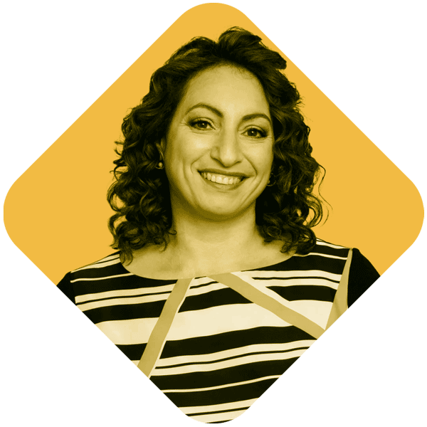 A woman with curly hair smiling, wearing a black and white striped top, against a yellow background framed in a diamond shape.
