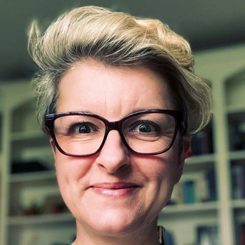 Close-up of a person with short blond hair and glasses smiling, indoors. Aneta heads up the People function in EuroNorth for Dassault Systemes - they have experienced hugely improved retention and internal mobility from using The Career Equation