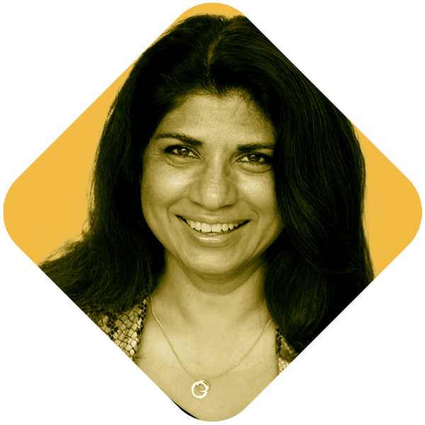 Portrait of a smiling woman with dark hair, wearing a necklace, against a yellow background, captured in a diamond-shaped frame.