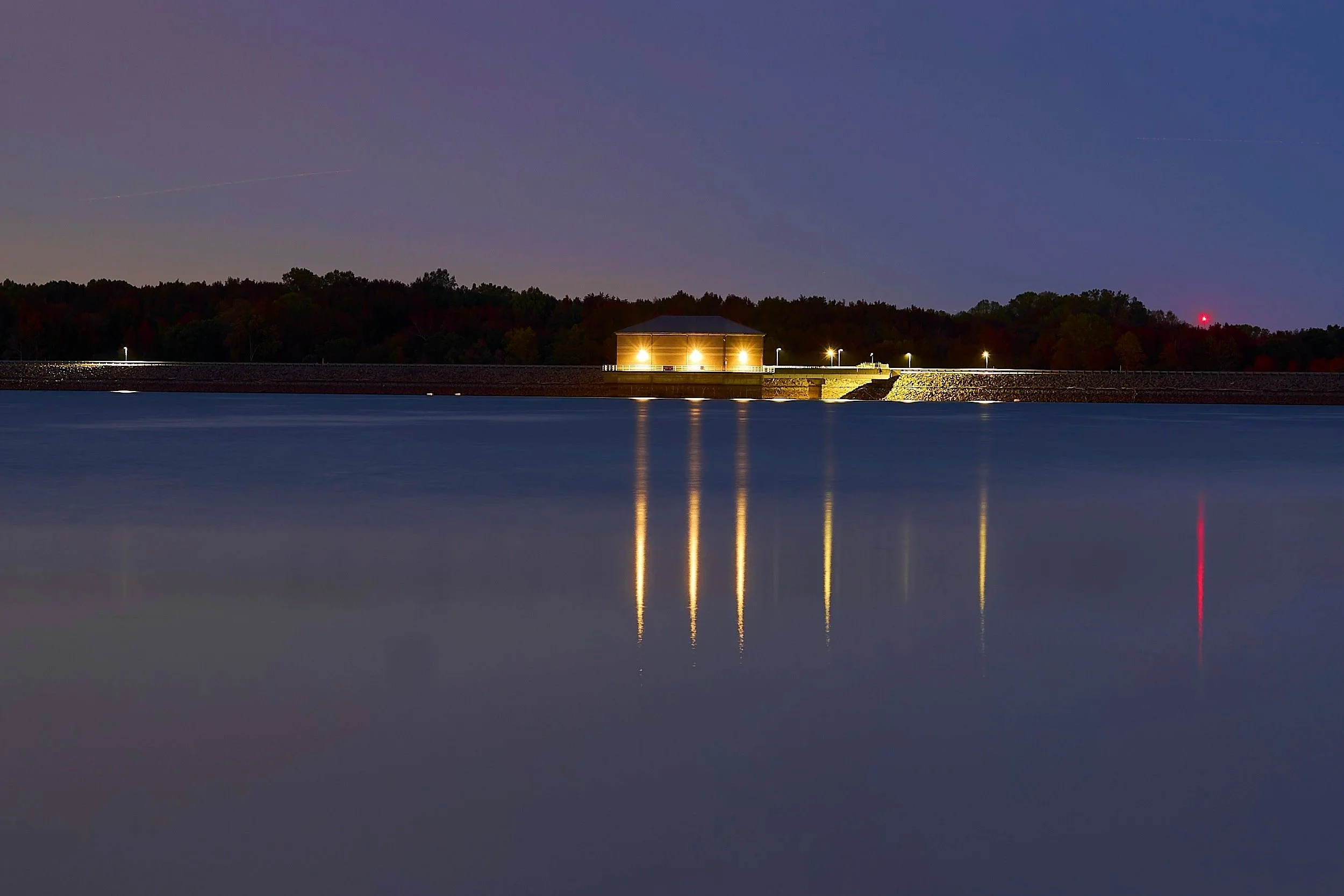 Damn at night with lights reflecting off the water. Manasquan Reservoir