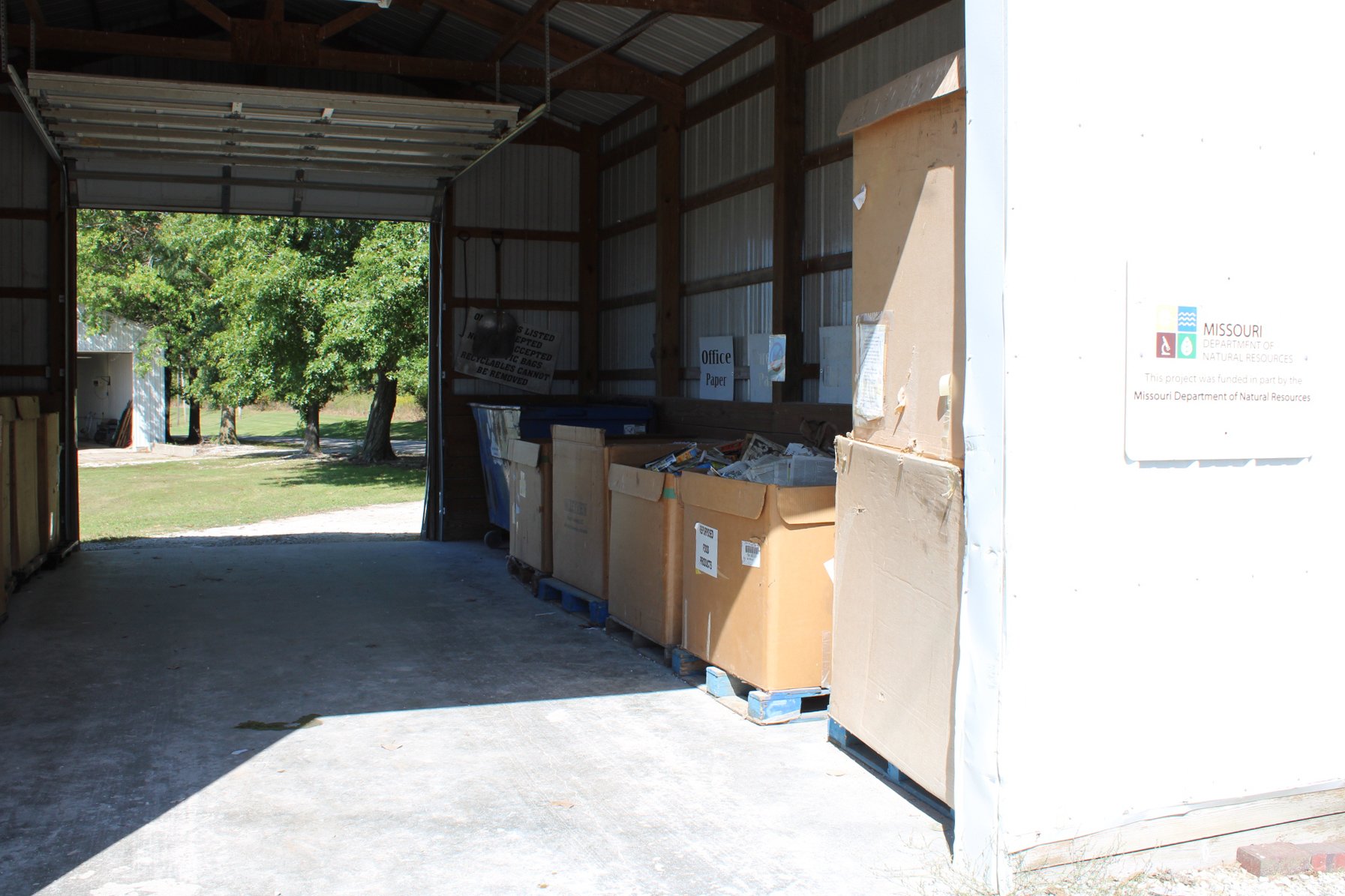 View inside a recycling station with cardboard boxes filled with paper and an 
