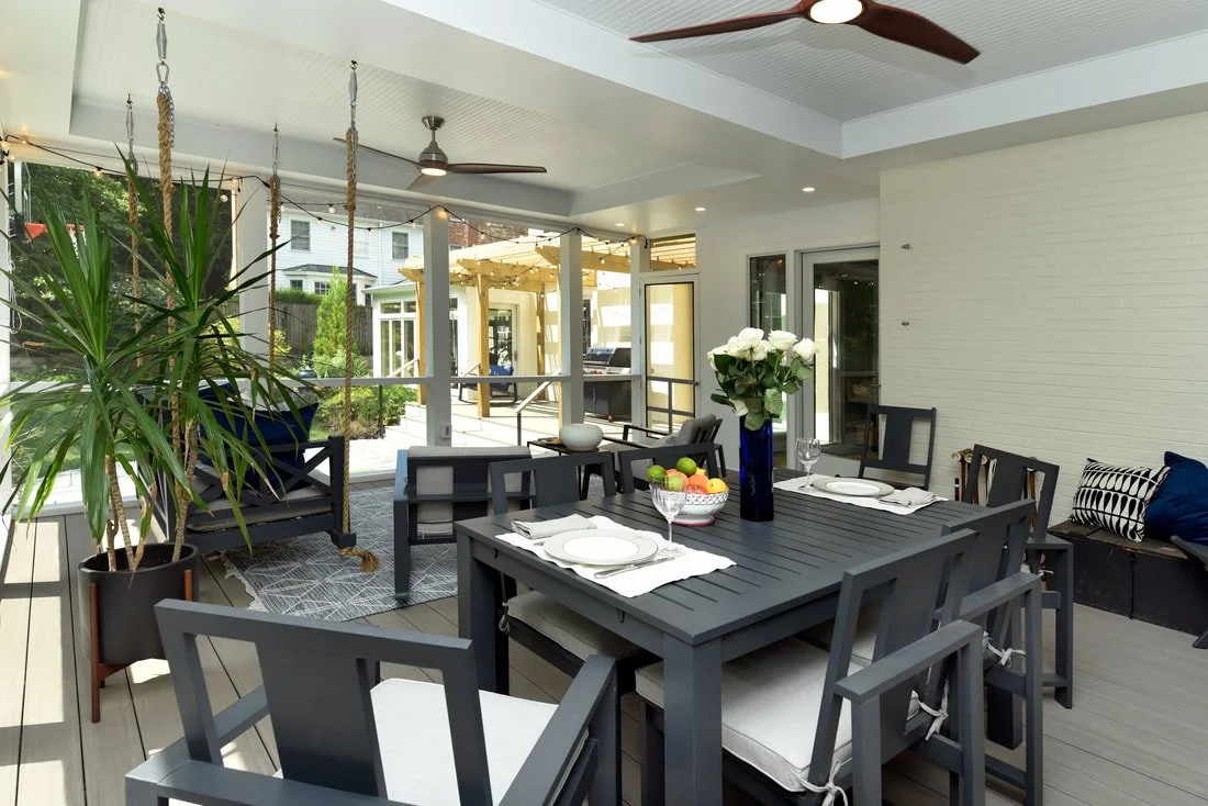 Covered outdoor patio with dining table, chairs, plant, and ceiling fans