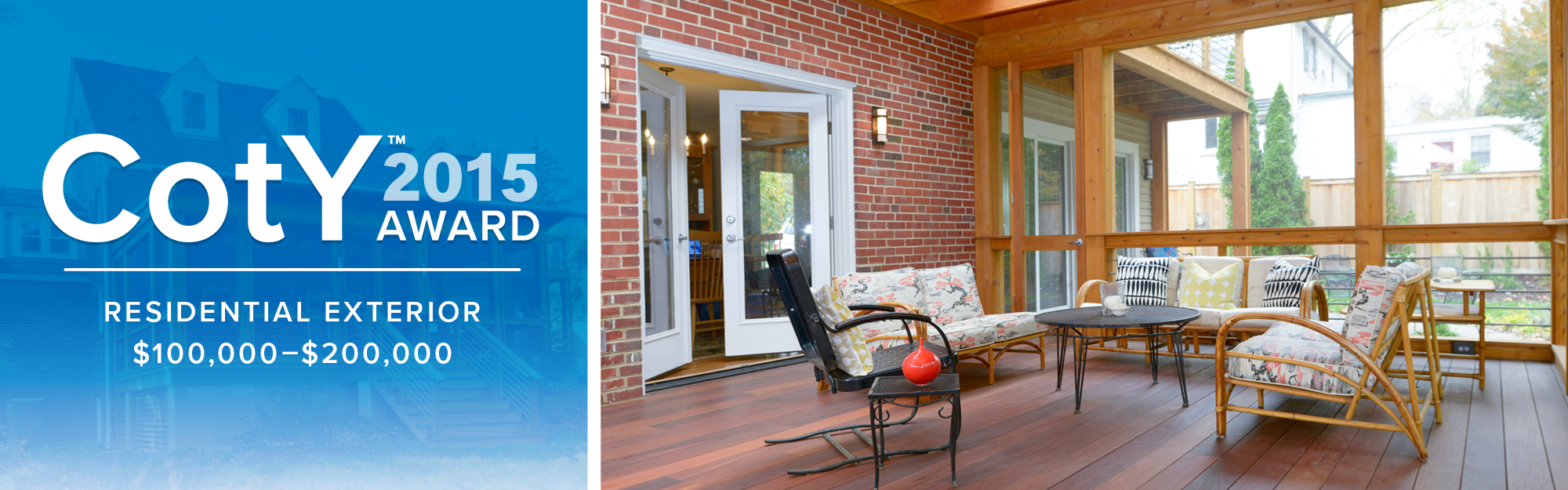 Covered patio with wicker and metal furniture, including cushioned chairs, a small side table, and a round coffee table, attached to a brick house with large glass doors and a wooden ceiling.
