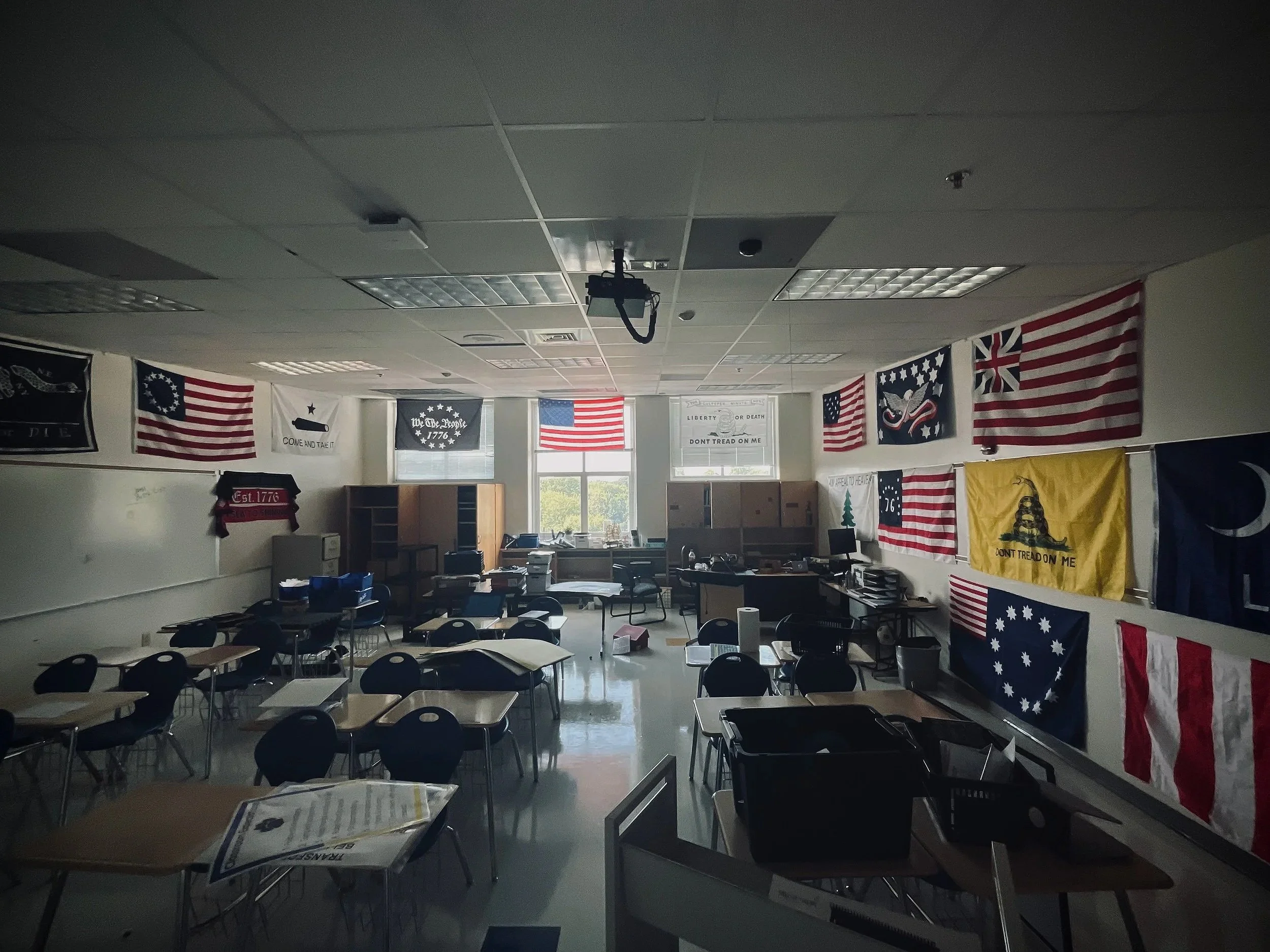 A classroom decorated with American flags and patriotic banners on the walls, with desks and chairs arranged inside.