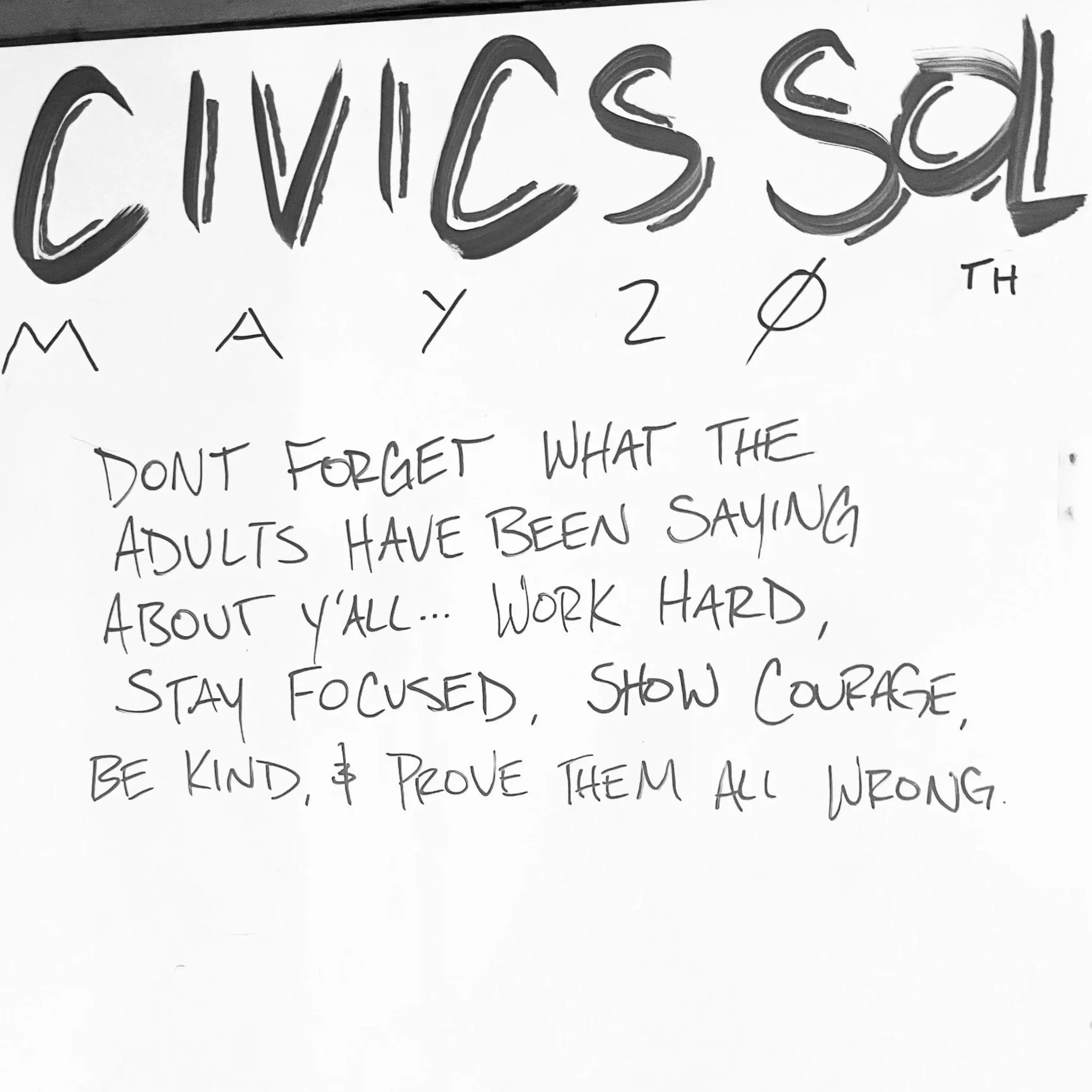 A handwritten note on white paper with a motivational message. The top part has large, stylized text that says 'CIVIC SOL' with smaller text below spelling 'MAY 20TH.' The message reads: 'Don't forget what the adults have been saying about y'all... work hard, stay focused, show courage, be kind, & prove them all wrong.'