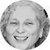 A black-and-white photo of a smiling elderly woman with curly hair.