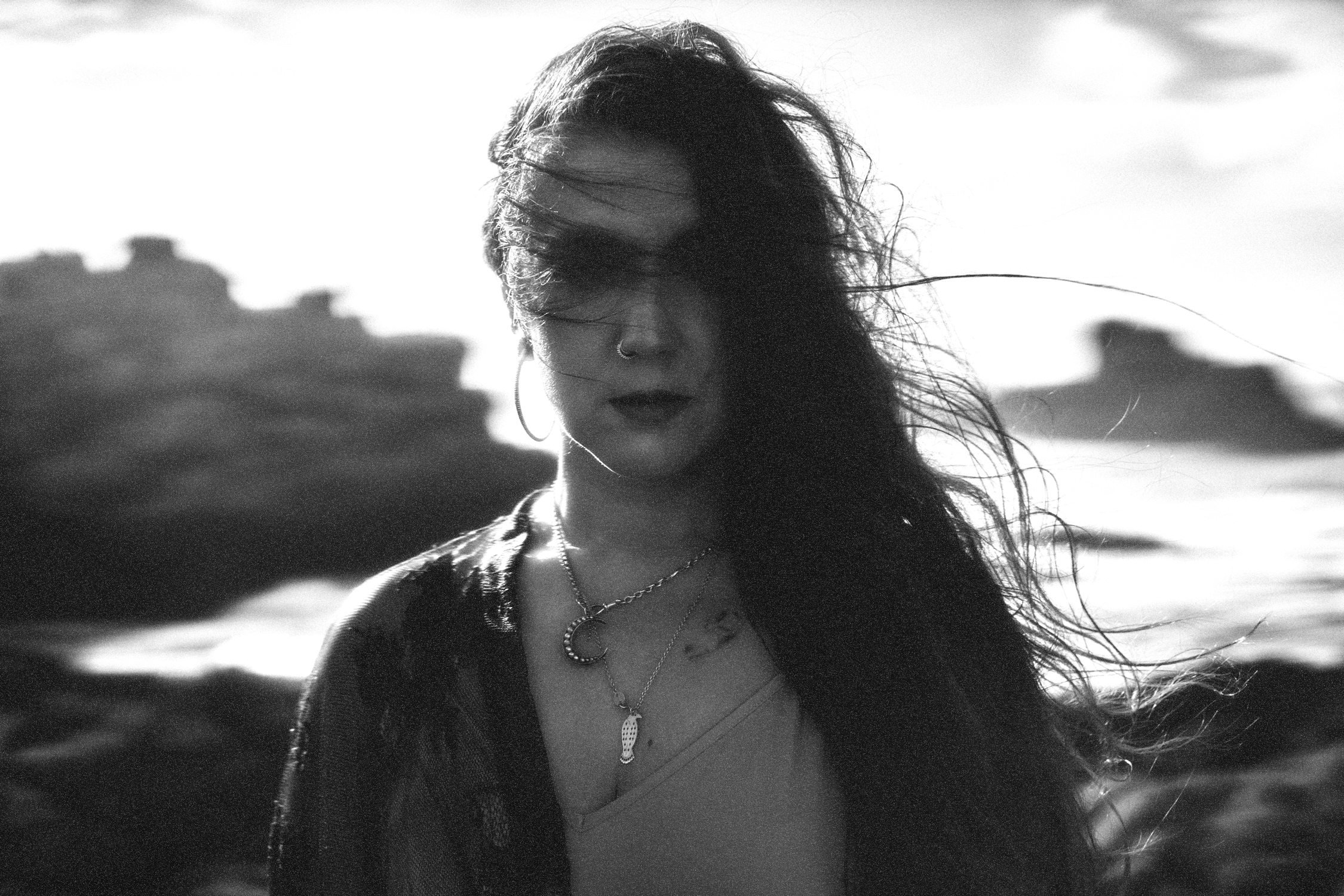 A person standing on snow-covered ground during a winter day, wearing a jacket and boots, facing away from the camera.