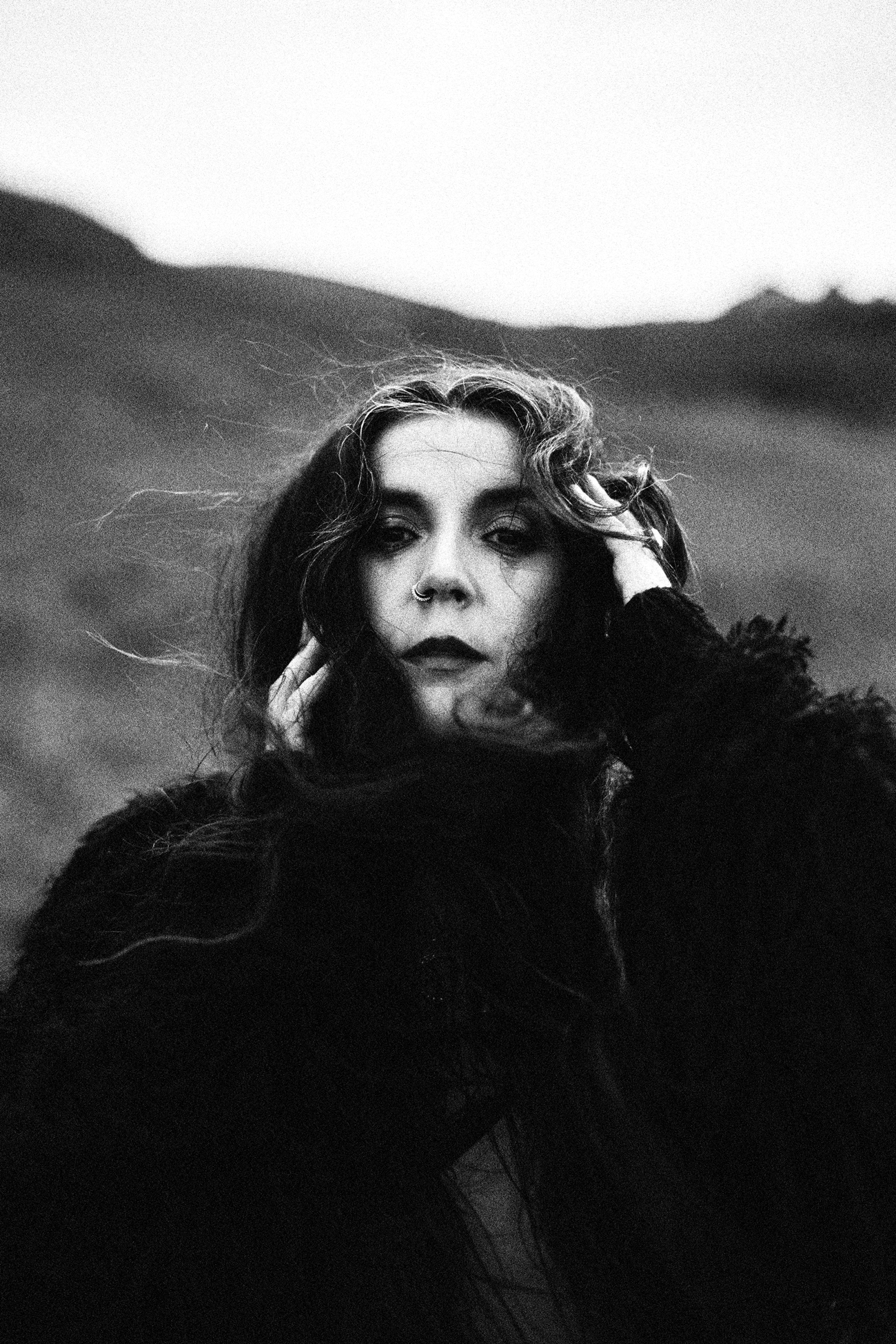 Black and white silhouette of a woman standing in a box with her arms raised, surrounded by abstract shapes and lines.