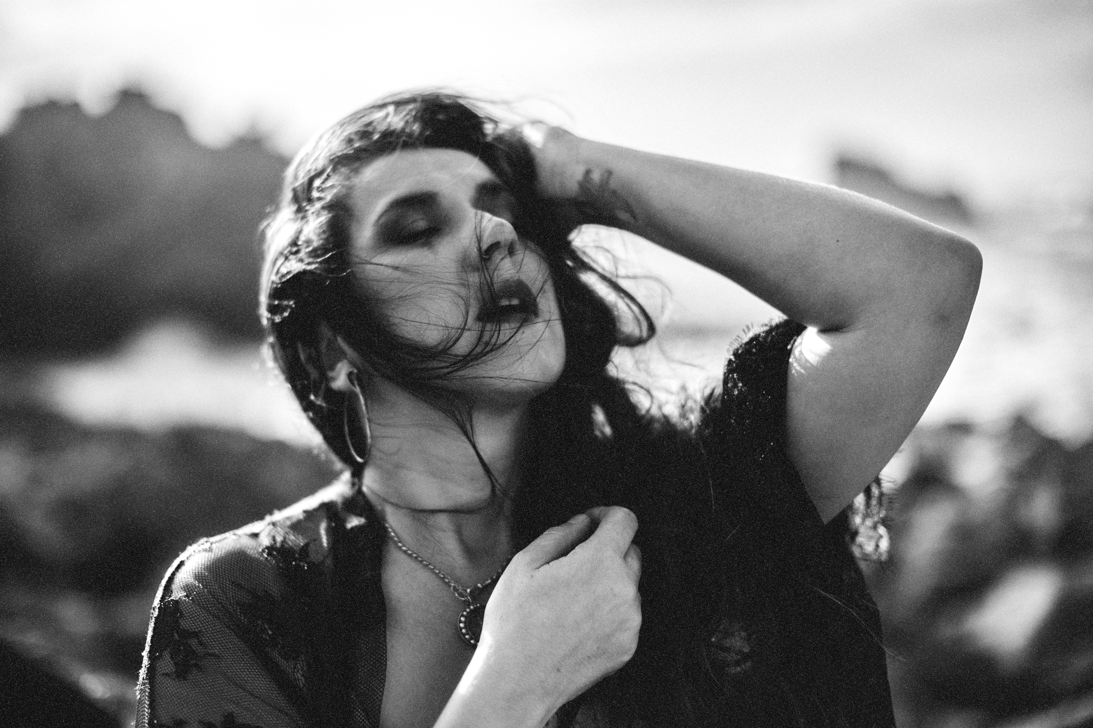 A person mountain biking on a trail surrounded by trees and rocky terrain.