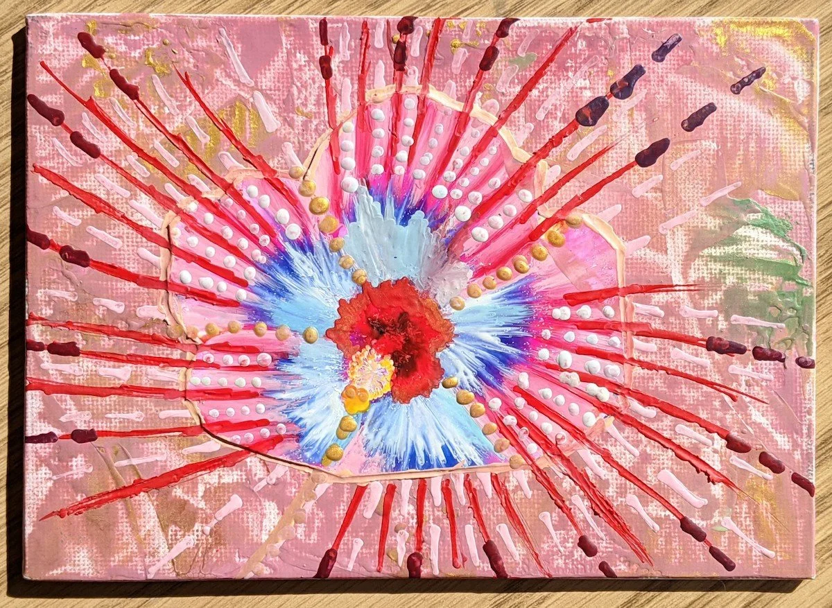 An abstract painting with a pink background, featuring a central explosion of red, white, blue, and yellow colors with radiating lines and textured paint splatters.
