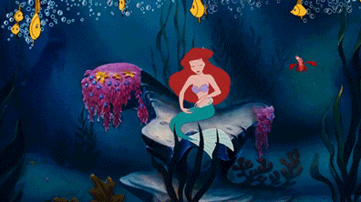 Animated scene of Ariel, the mermaid, sitting on a rock underwater surrounded by seaweed and colorful plants.