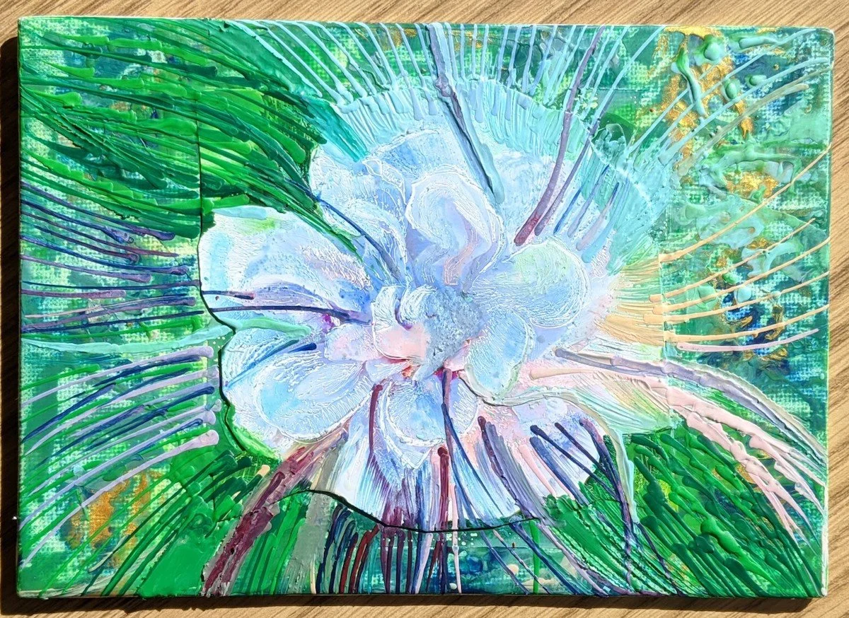 Abstract colorful painting featuring a white flower with green leaves and splashes of various colors.