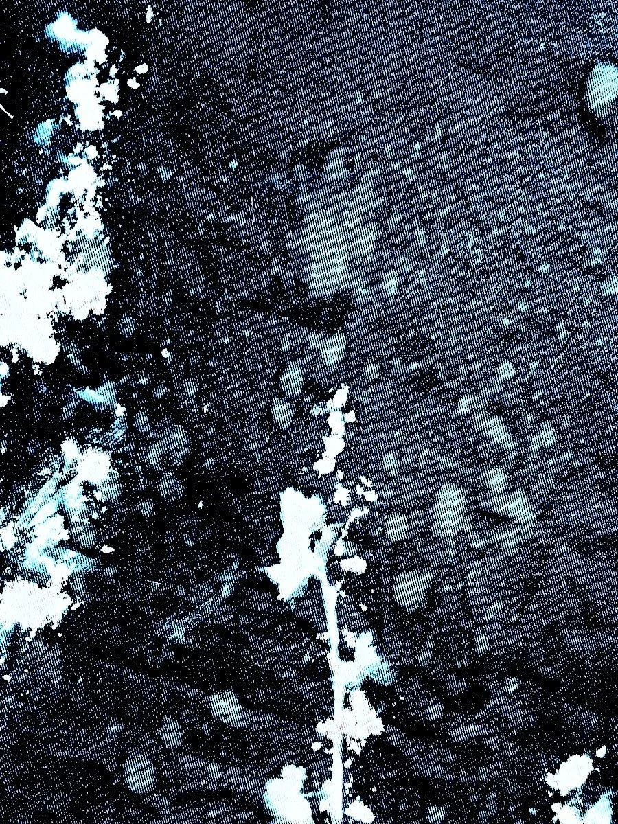 Close-up of black and white abstract pattern resembling ink splatters or paint on a textured surface.