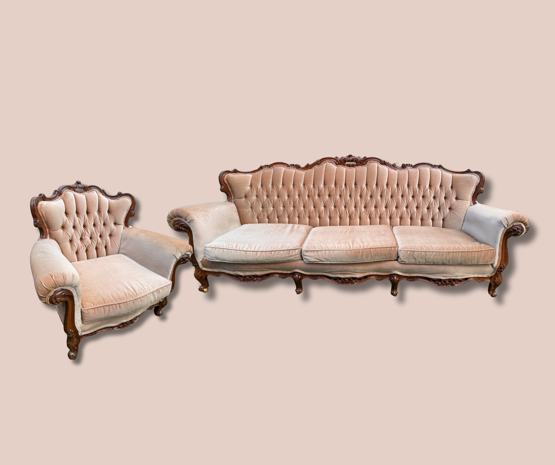 Vintage upholstered sofa and armchair set with carved wooden frames on a beige background.