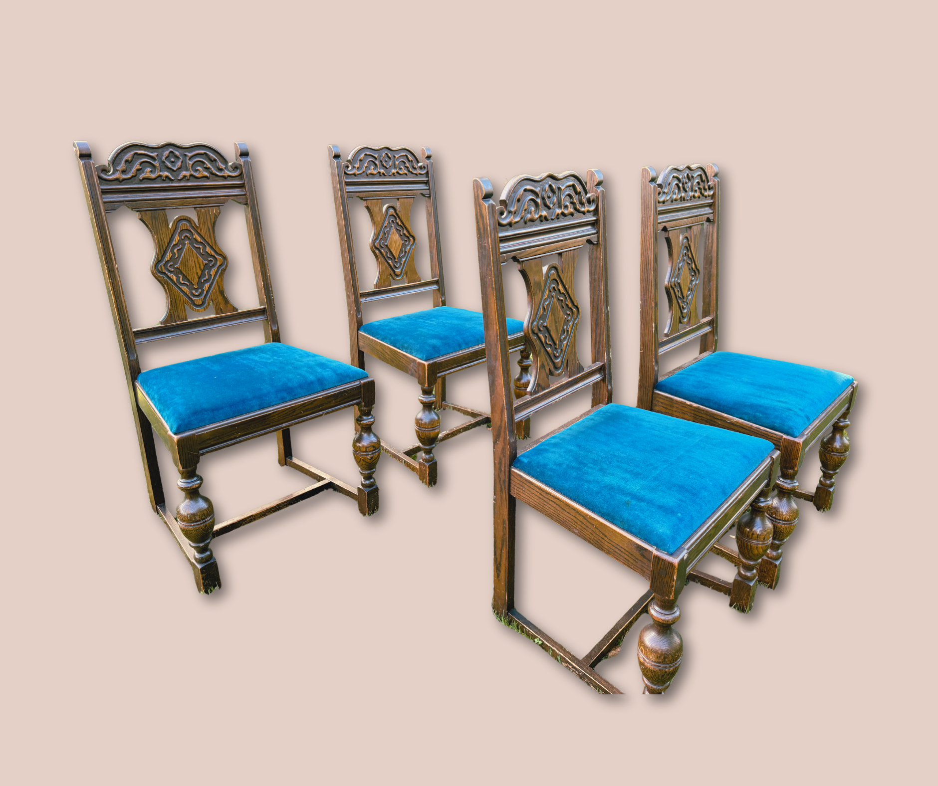 Four vintage wooden chairs with ornate backrests and blue upholstered seats, arranged against a plain neutral background.