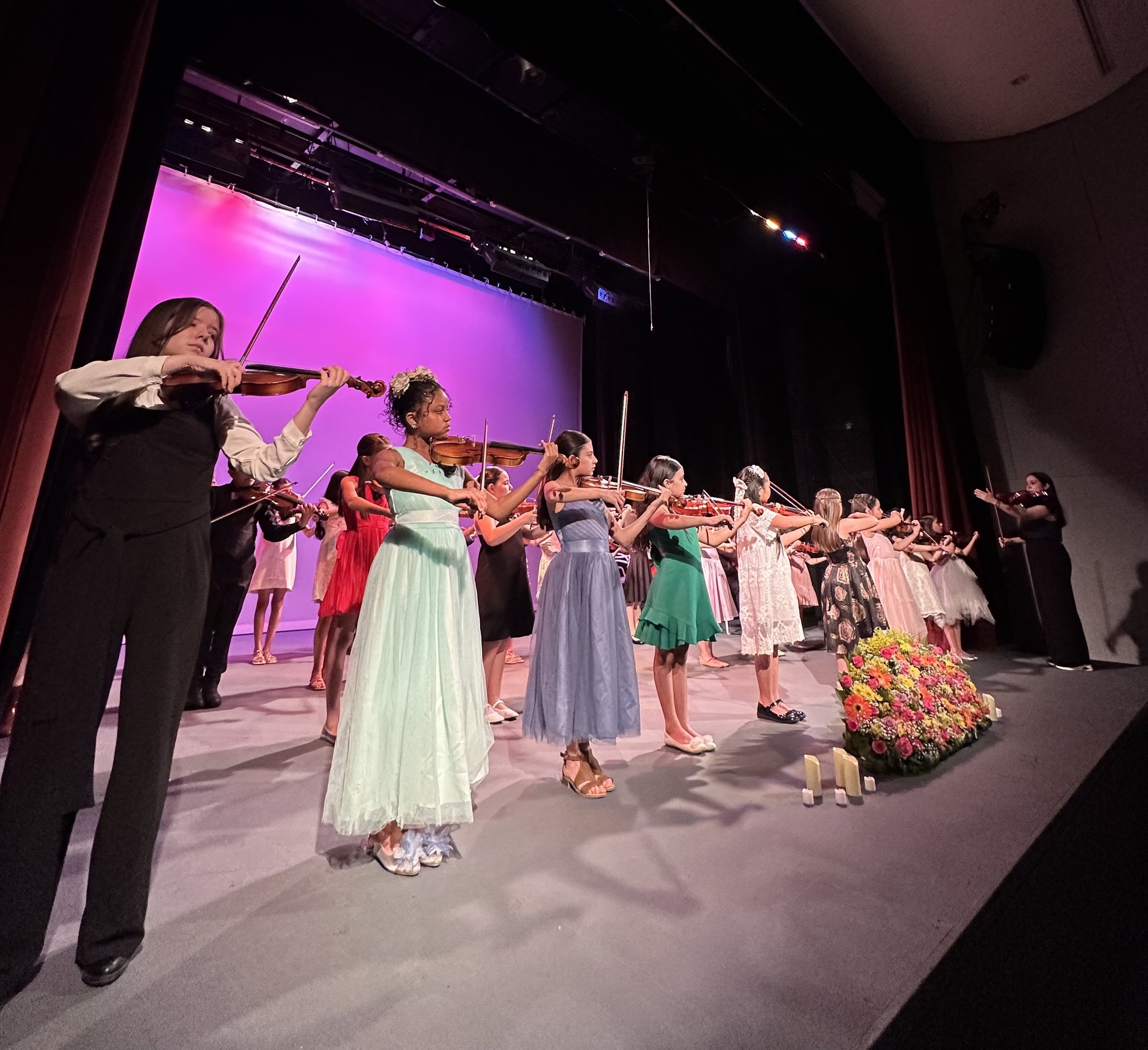 Grupo de alumnos de violín presentándose en recital en Monterrey tras proceso de preparación en Academy of Musical Excellence