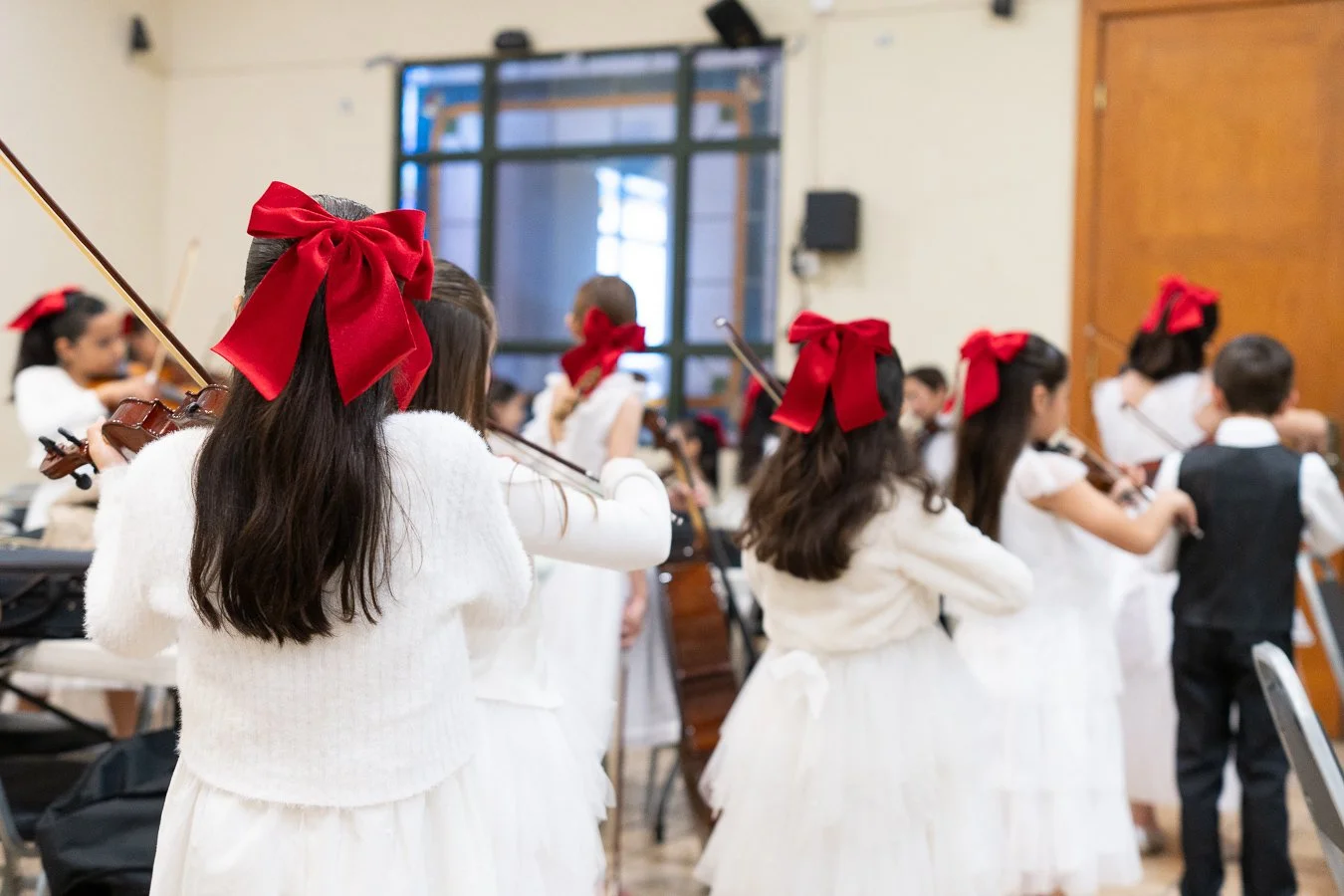 Niños y niñas tocando violín en un concierto, clases de violín en Monterrey en AME.