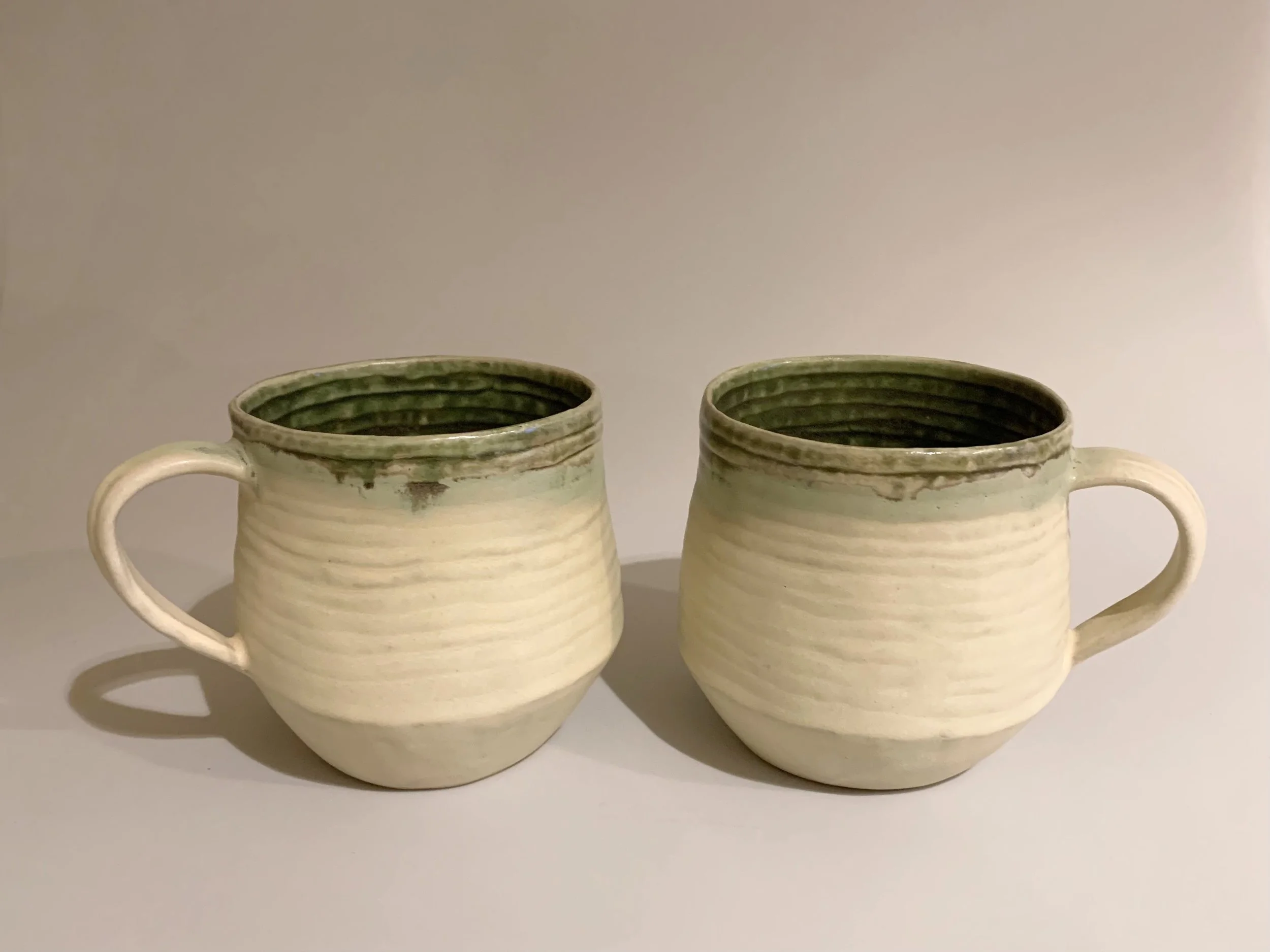 Coiled Mugs, Green and Ivory. Porcelain. Dimensions each: 13.5 W x 9.5cm H x 10cm D.