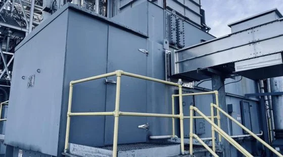 Industrial HVAC unit with yellow safety railings and stairs