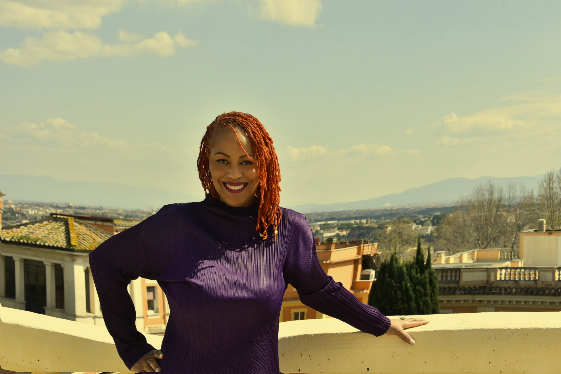 Samiya Bashir -- in a purple dress, standing on a rooftop in Rome, Italy, 2026