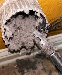 A dryer vent being cleaned out and pulling out debris, allergens, pet hair, and dust