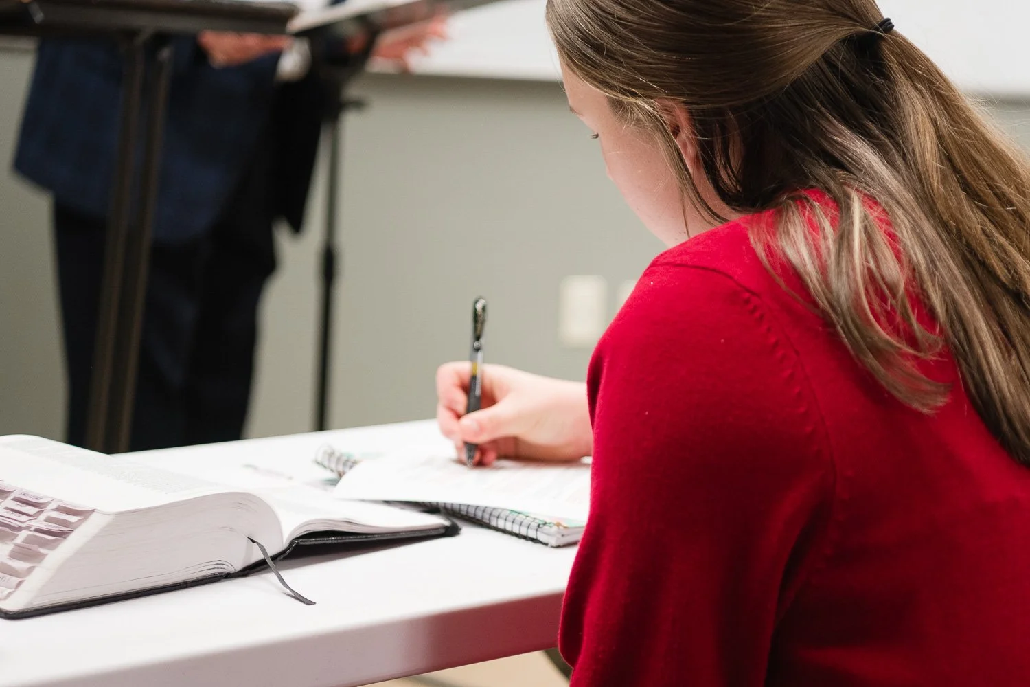 Girl taking notes in Bible class