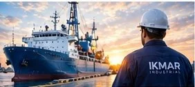Hombre con casco observando un barco en el puerto durante el atardecer