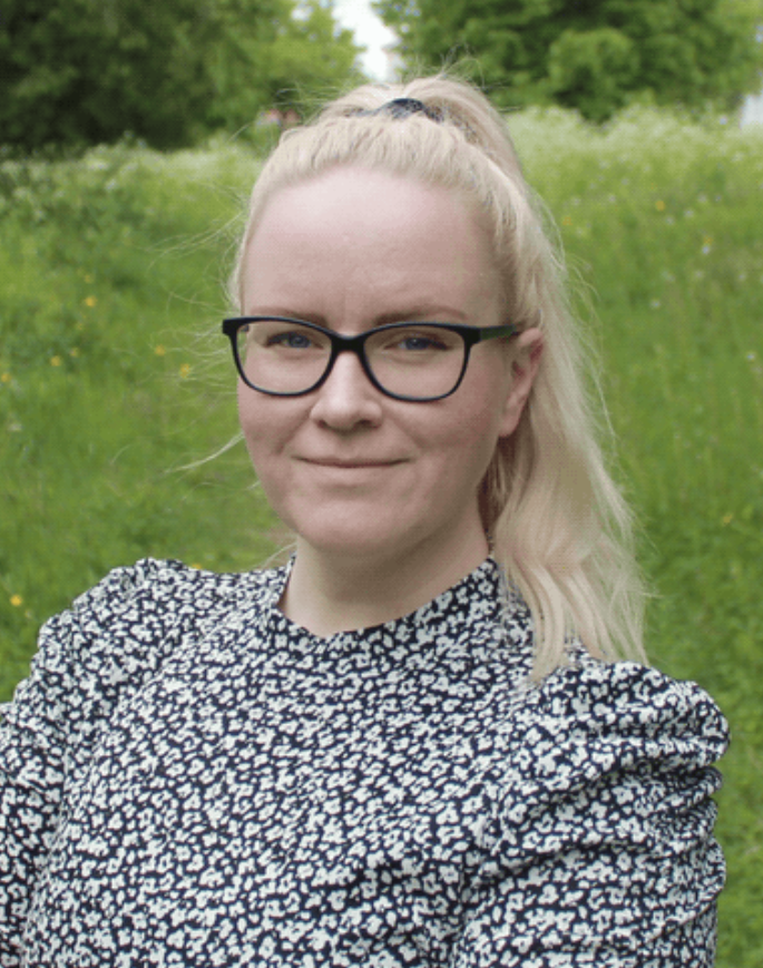 YKES:n jäsen Eeva Nikkilä kuvattuna ulkona, taustalla kesäinen, vihreä niitty.