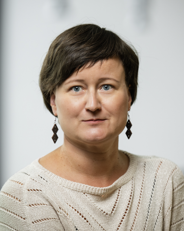 YKES:n jäsen Outi Ratamäki kuvattuna studiossa vaaleaa taustaa vasten.