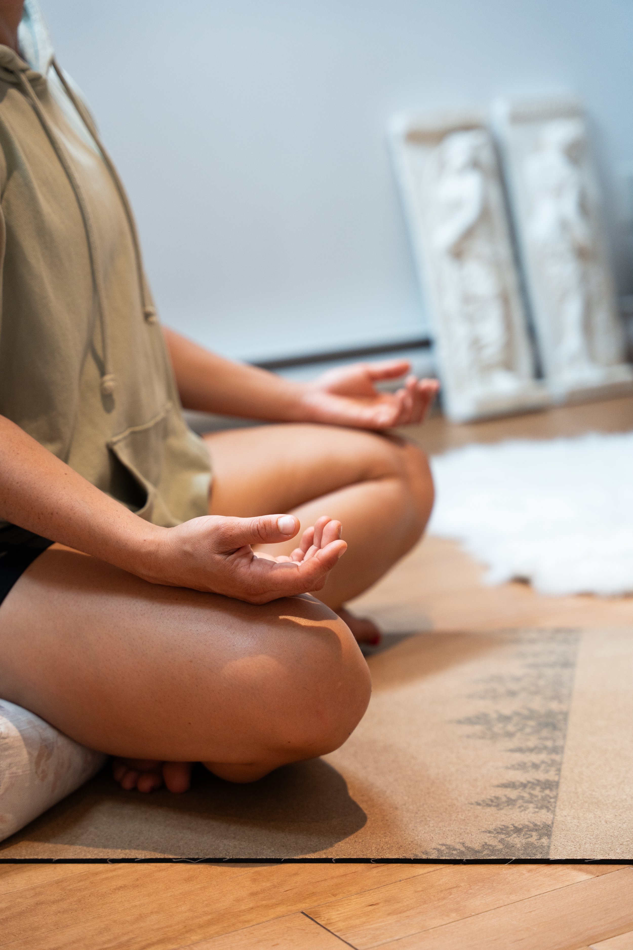 Une personne pratiquant la méditation en position de lotus dans une pièce calme.