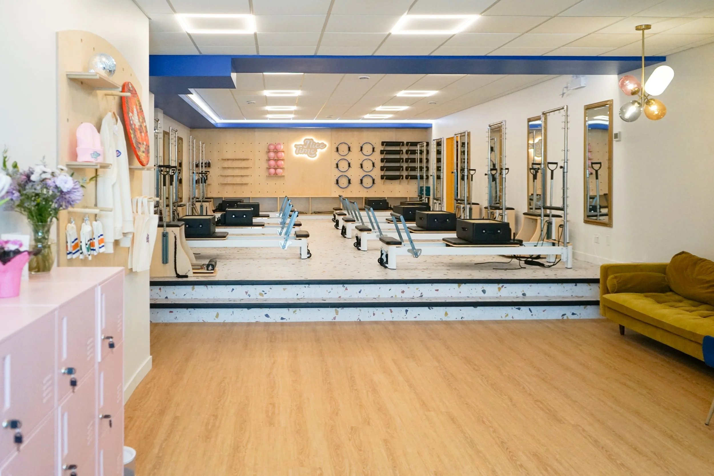 nice time pilates studio floor with reformers, towers, chairs and mat