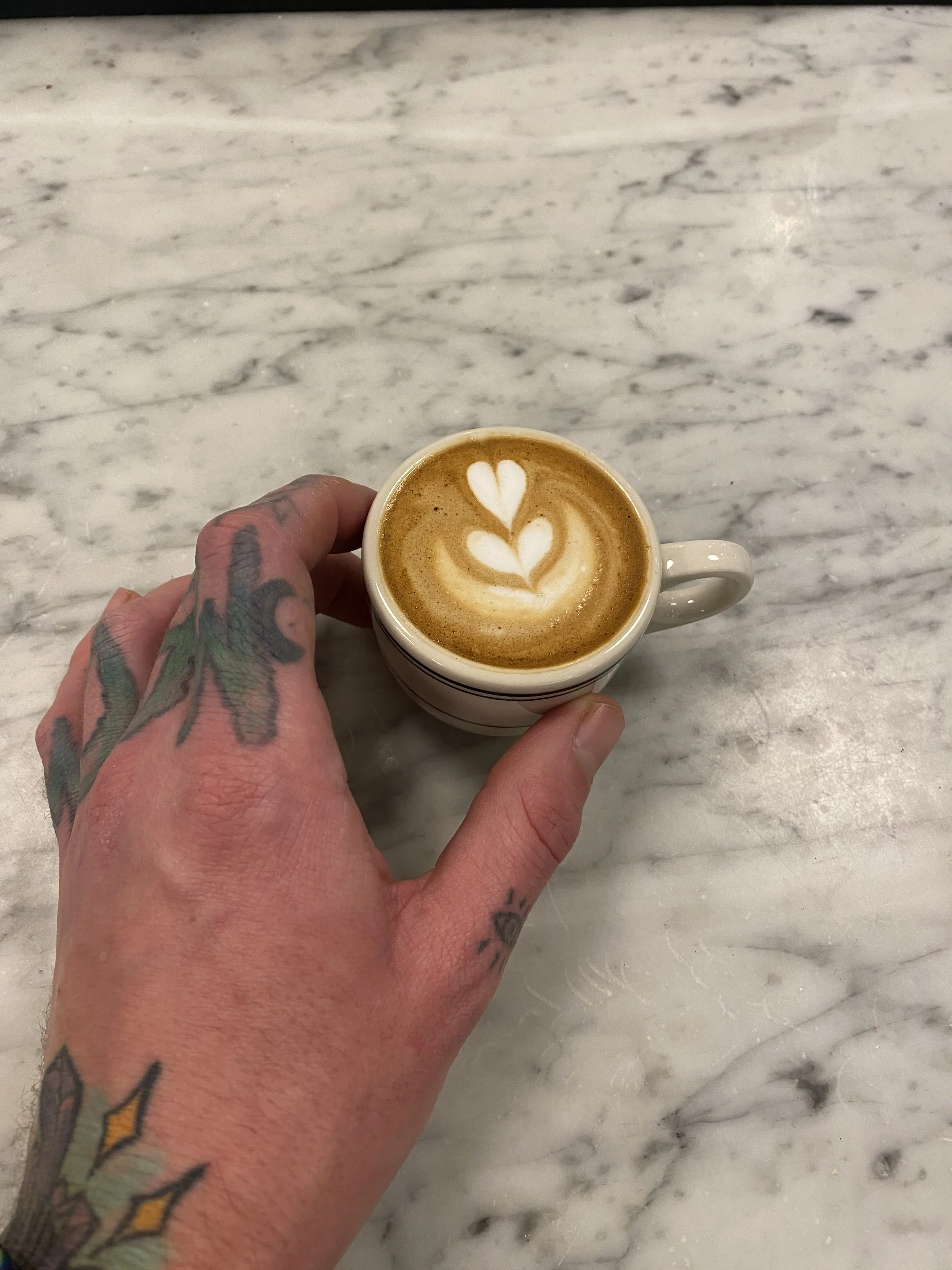 Daniel Karl Nennig holding a double macchiato he prepared.