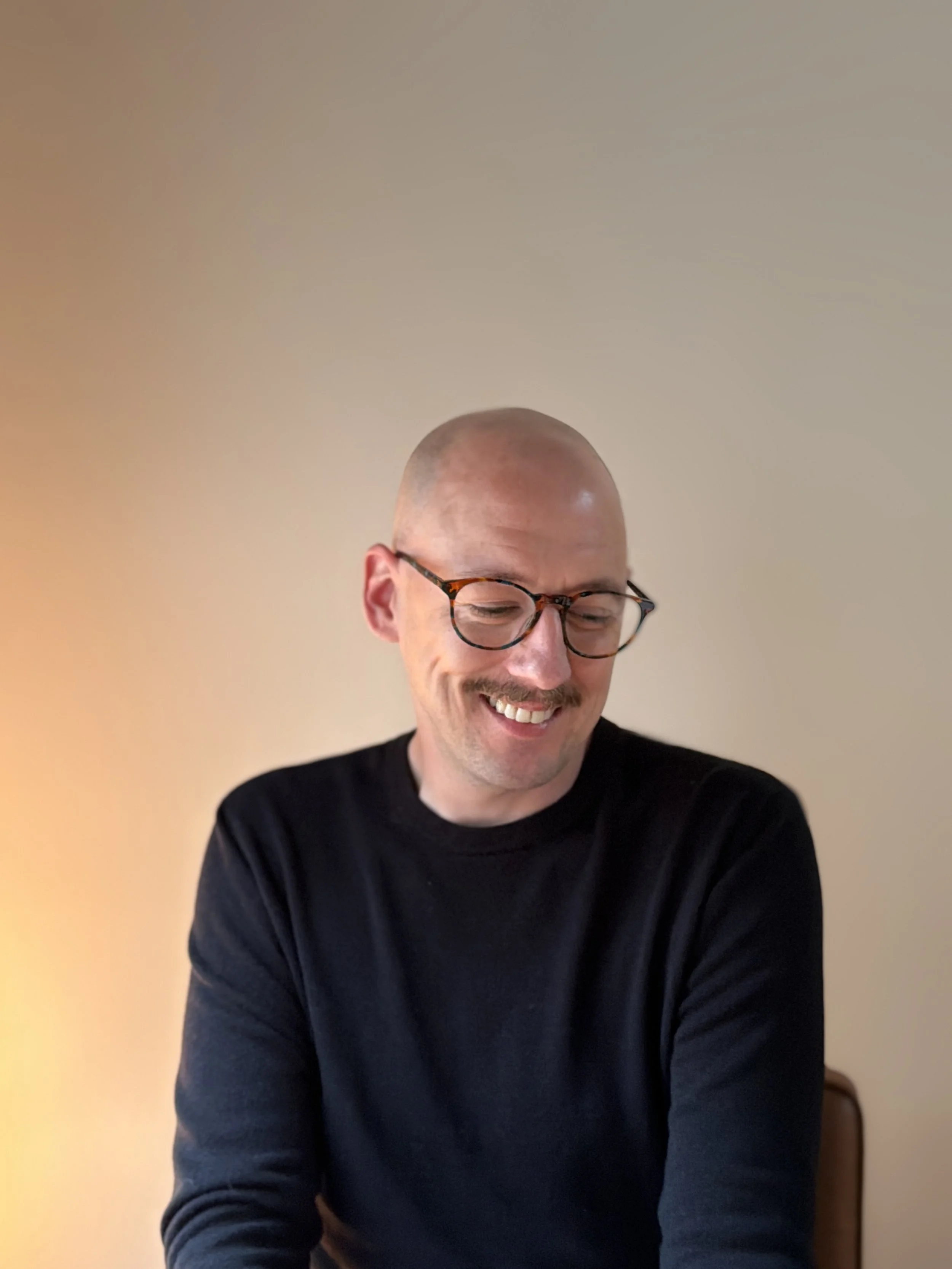 Daniel Karl Nennig smiling while seated indoors.