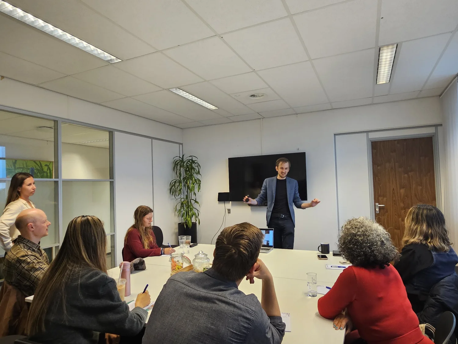 A trainer speaking to a group seated around a table