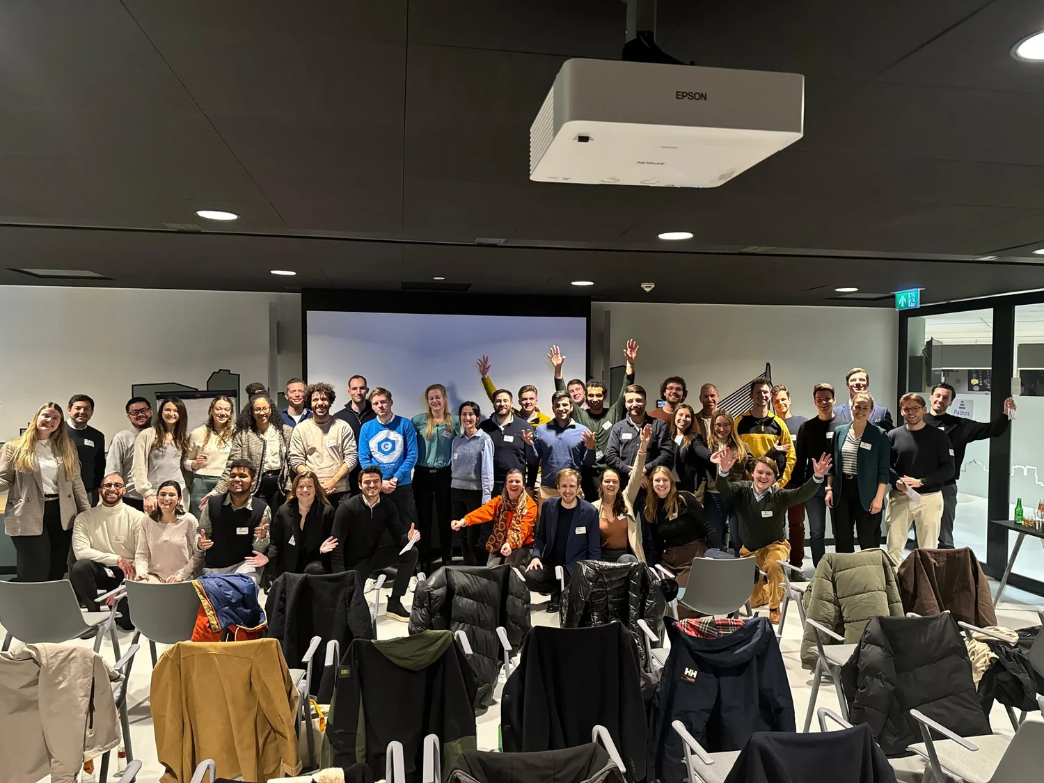 A large group of participants cheering at the end of a LifeVersity workshop