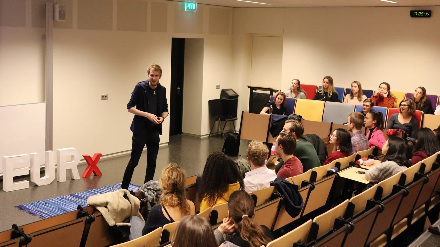 A speaker presenting to students in a lecture hall at Erasmus University Rotterdam