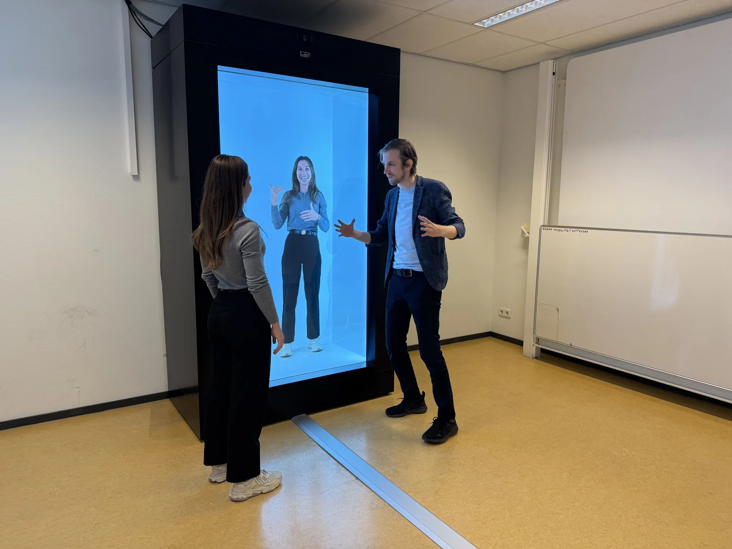 A trainer and participant practising with a life-size virtual presenter