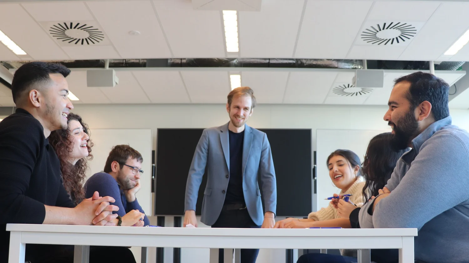 Matt laughing with a group of participants around a table