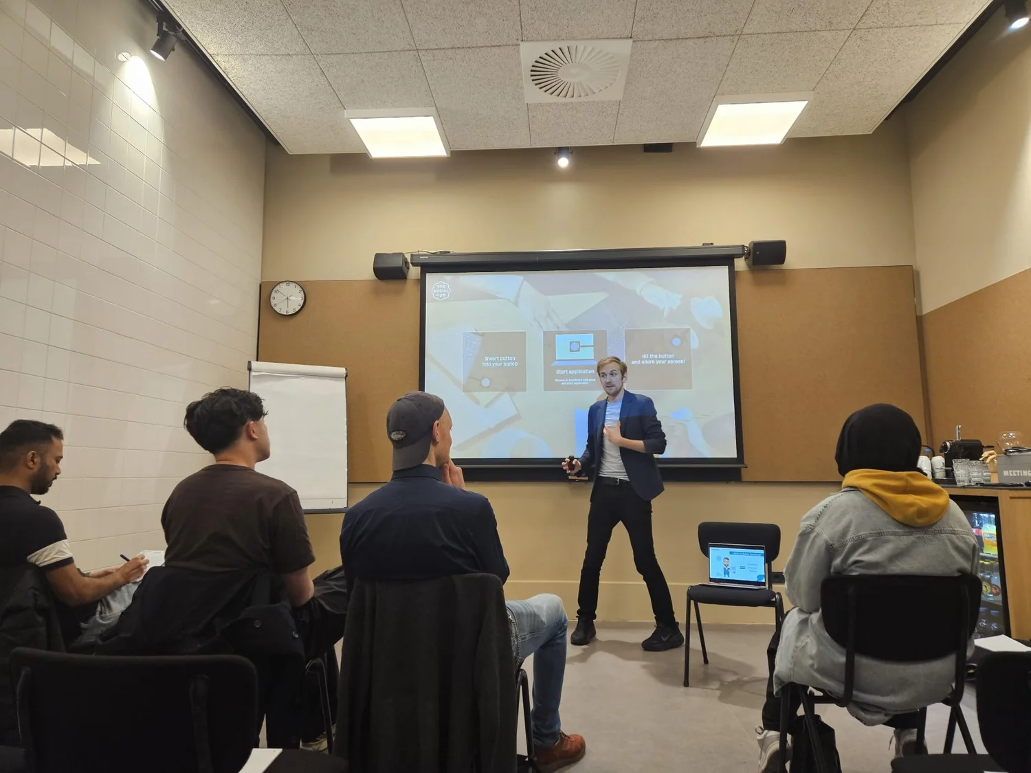 A participant speaking in front of a small seated group
